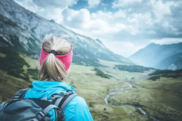 Female blonde mountain climber with backpack is enjoying the vie — Stock Photo, Image