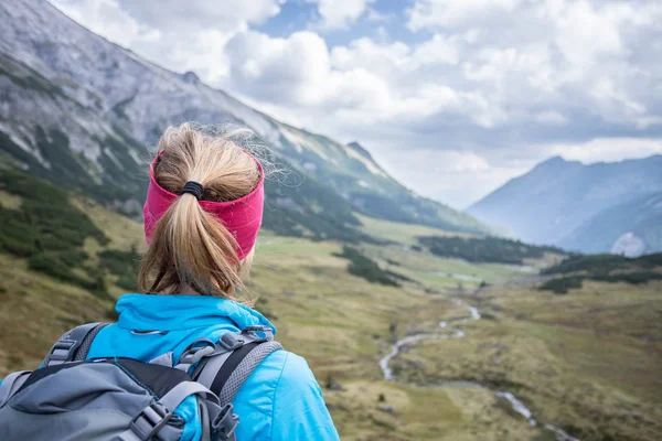 Mujer rubia montañista con mochila está disfrutando de la competencia —  Fotos de Stock