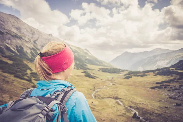 Female blonde mountain climber with backpack is enjoying the vie — Stock Photo, Image