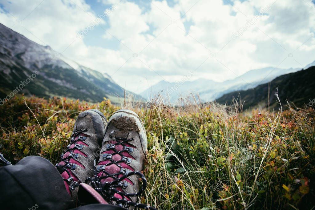 Alpine boots in foreground, idyllic mountain landscape in the bl