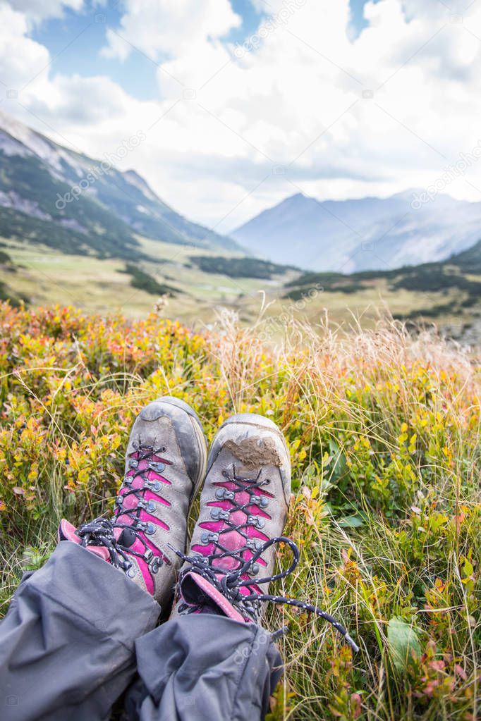 Alpine boots in foreground, idyllic mountain landscape in the bl