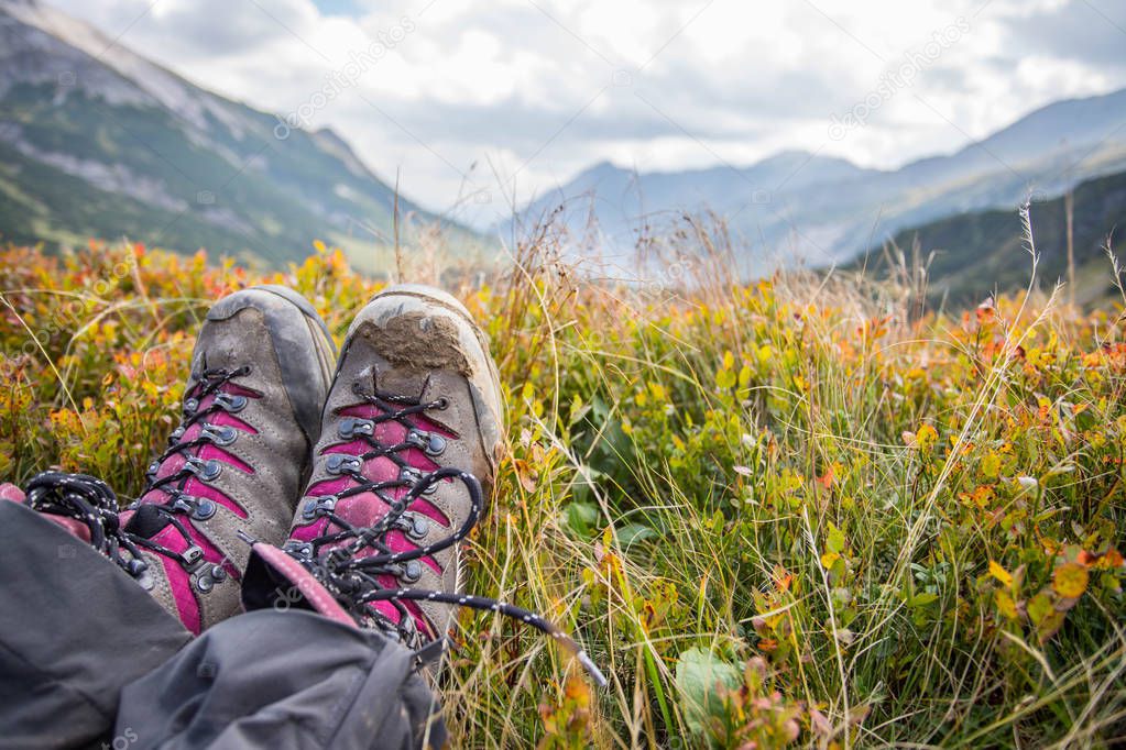 Alpine boots in foreground, idyllic mountain landscape in the bl