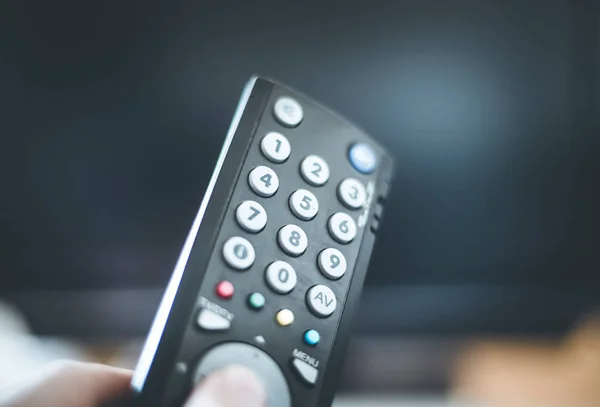 Male hand is holding TV remote control, smart TV. — Stock Photo, Image