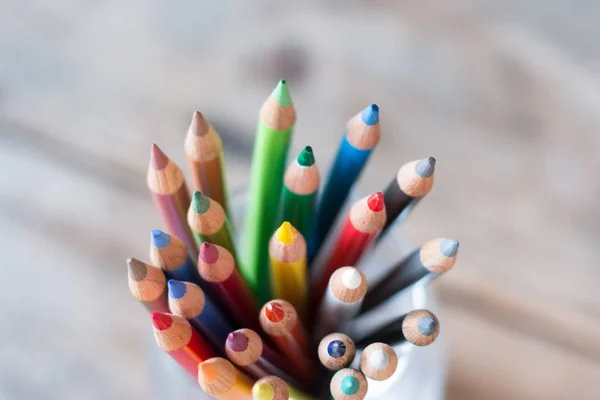 Creativiteit: Kleurpotloden in een blikje op rustieke houten tafel — Stockfoto