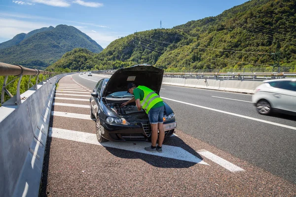 Mécanicien en gilet réfléchissant essaie de réparer une panne ca — Photo