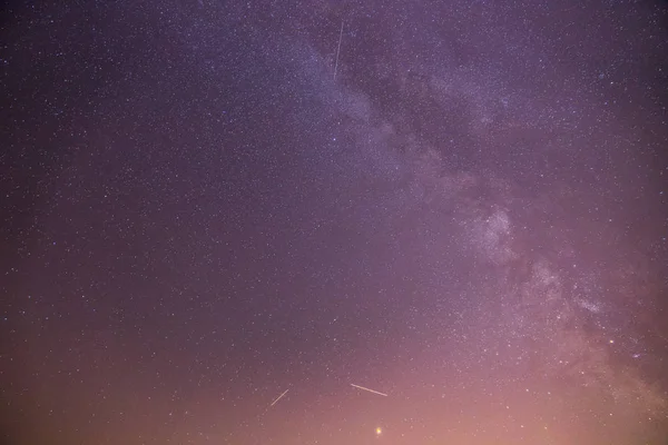 Nacht landschap: sterren, weide en een boom. Paarse en warme tinten — Stockfoto