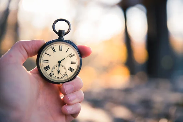 Tiden går: vintage klocka utomhus, handhållna; trä och löv — Stockfoto