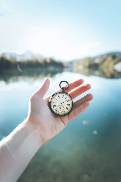 Vintage watch hand-held, autumwn view with lake and trees in the — Stock Photo, Image