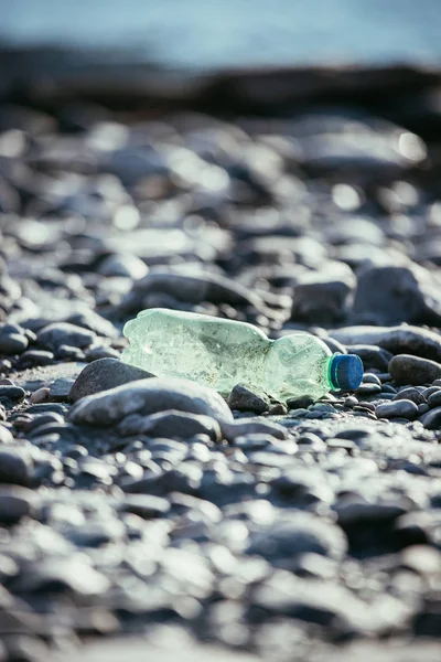 Poluição ambiental: garrafa de plástico na praia — Fotografia de Stock