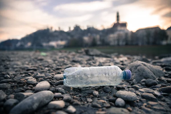 Poluição ambiental: garrafa de plástico na praia, cidade urbana — Fotografia de Stock