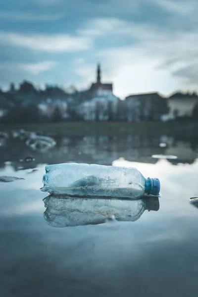 Environmental pollution: plastic bottle on the beach, urban city — Stock Photo, Image