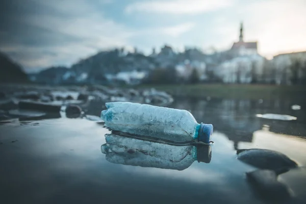 Environmental pollution: plastic bottle on the beach, urban city — Stock Photo, Image