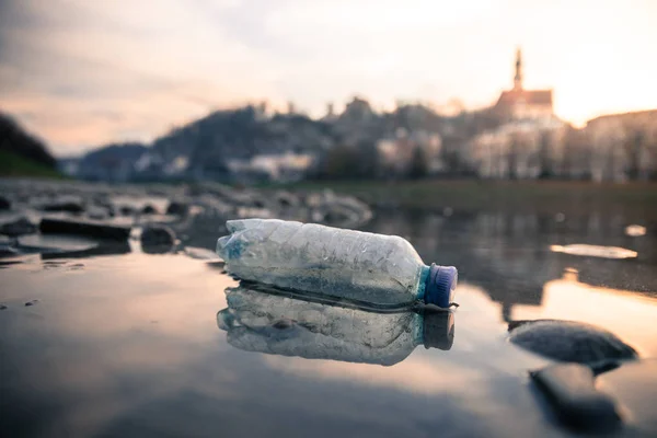 Environmental pollution: plastic bottle on the beach, urban city