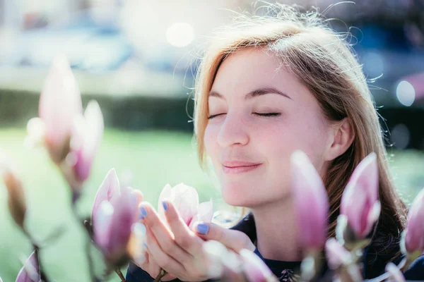Menina bonita está cheirando flores de magnólia na primavera, Salzburgo , — Fotografia de Stock