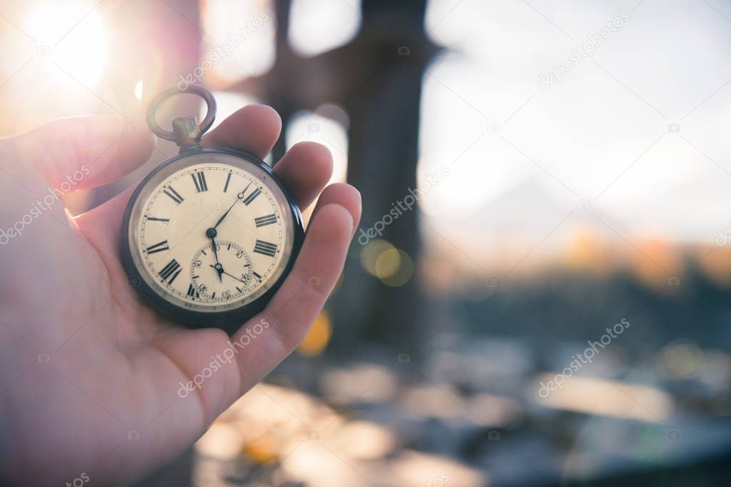 Time goes by: vintage watch outdoors, hand-held; wood and leaves