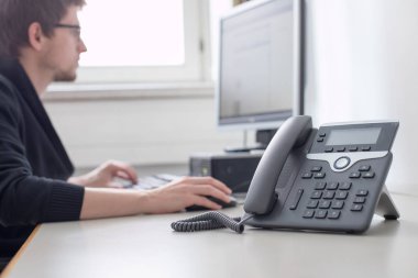 Çalışan müşterilerle telefonda konuşuyor