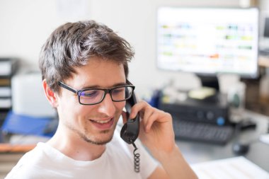Çalışan müşterilerle telefonda konuşuyor