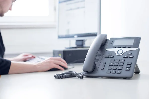 Empregado está falando ao telefone com os clientes — Fotografia de Stock