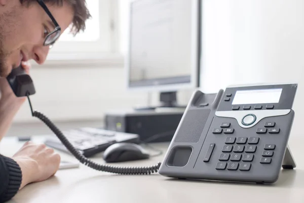 Empregado está falando ao telefone com os clientes — Fotografia de Stock