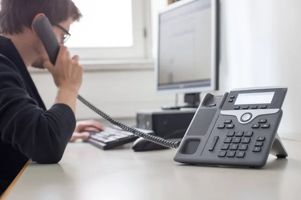 Empregado está falando ao telefone com os clientes — Fotografia de Stock