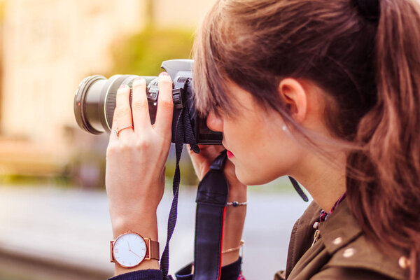 Young female tourist girl is taking shots with her camera