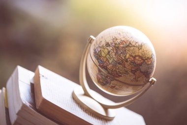 Sonraki yolculuk planlama: bir kitap yığını üzerinde minyatür dünya.