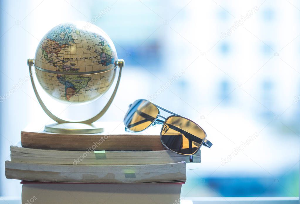 Planning the next journey: Miniature globe and sunglasses on a s