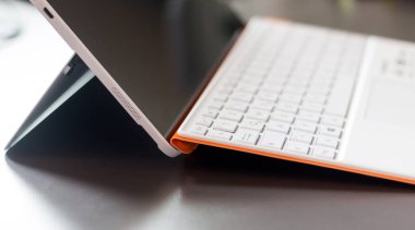 Beyaz turuncu konvertibıl laptop ve klavye