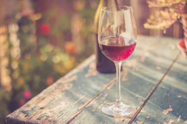 Bir bardak kırmızı şarap kendi bahçesinde zevk. Rustik, eski tabl