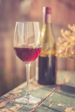 Bir bardak kırmızı şarap kendi bahçesinde zevk. Rustik, eski tabl