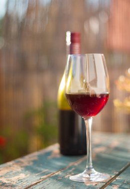 Bir bardak kırmızı şarap kendi bahçesinde zevk. Rustik, eski tabl