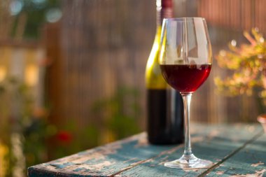 Bir bardak kırmızı şarap kendi bahçesinde zevk. Rustik, eski tabl