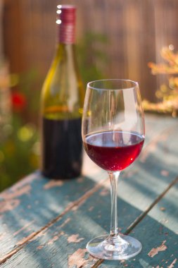 Bir bardak kırmızı şarap kendi bahçesinde zevk. Rustik, eski tabl