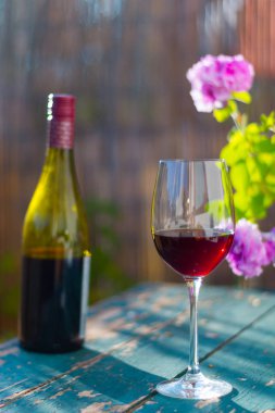 Bir bardak kırmızı şarap kendi bahçesinde zevk. Rustik, eski tabl