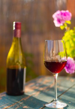 Bir bardak kırmızı şarap kendi bahçesinde zevk. Rustik, eski tabl