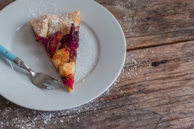 Rustik ahşap bir masa üzerinde bir taze Erik pasta dışarı kesmek yaz