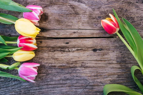 Regeling van kleurrijke tulpen op een rustieke houten tafel, tekst sp — Stockfoto