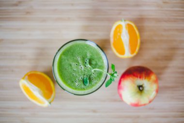 Günaydın: taze yeşil smoothie ve meyve üzerinde ahşap backgrou