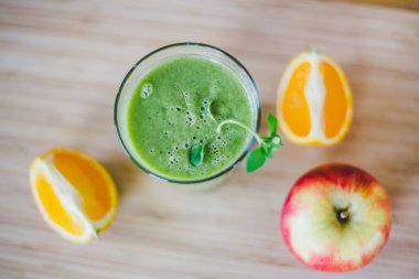 Günaydın: taze yeşil smoothie ve meyve üzerinde ahşap backgrou