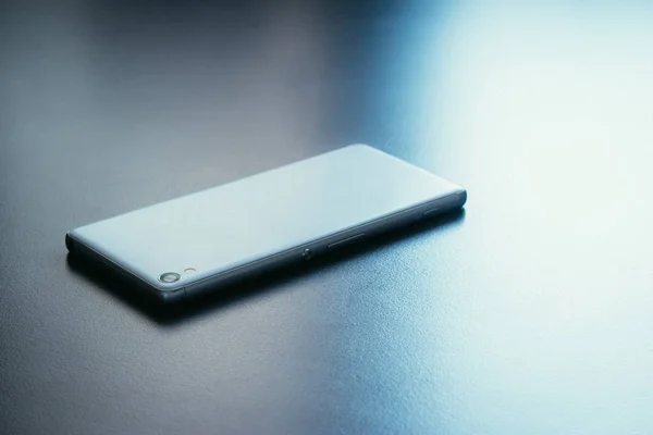 Smart phone: Phone is lying on a grey table, perspective view