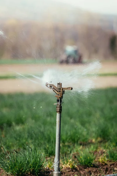 Impianto di irrigazione su un campo, agricoltura. Trattore nel — Foto Stock