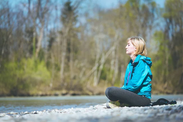 Meditación y relajación: La mujer está meditando al aire libre sobre un peb —  Fotos de Stock