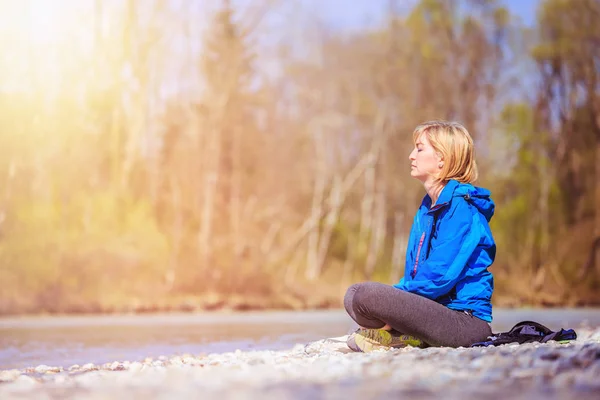 Meditación y relajación: La mujer está meditando al aire libre sobre un peb —  Fotos de Stock
