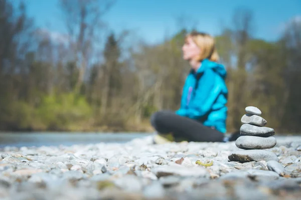 Meditation and relaxation: Cairn in the foreground, meditating w — Stock Photo, Image