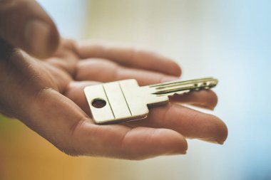 Yeni bir ev içine hareket: bir el bir anahtar tutarak kapatın. Uygun