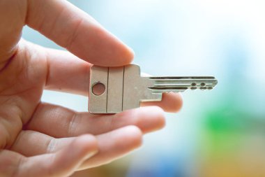 Yeni bir ev içine hareket: bir el bir anahtar tutarak kapatın. Uygun