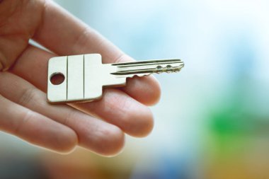 Yeni bir ev içine hareket: bir el bir anahtar tutarak kapatın. Uygun