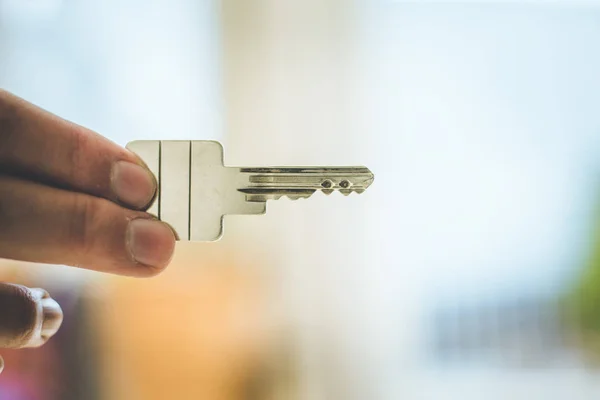 Emménager dans une nouvelle maison : Gros plan d'une main tenant une clé. Propre — Photo