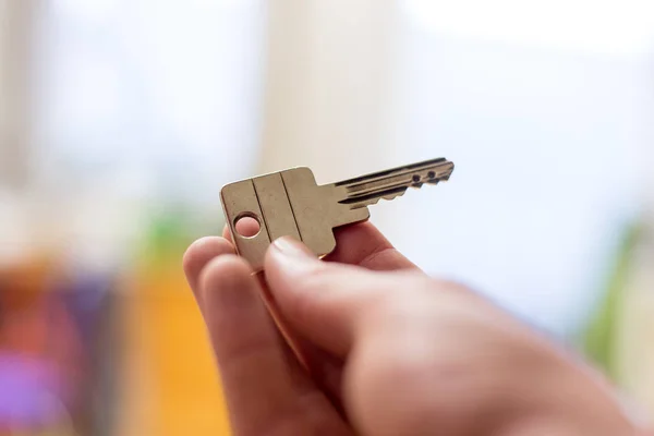 Moving into a new home: Close up of a hand holding a key. Proper