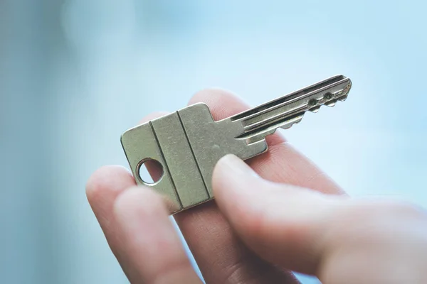 Emménager dans une nouvelle maison : Gros plan d'une main tenant une clé. Propre — Photo